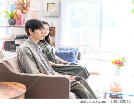 一對年輕夫婦並排坐在沙發上。 139680072