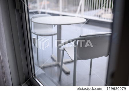 Outdoor tables and chairs seen through the window Outdoor tables and chairs seen through the window 139680079