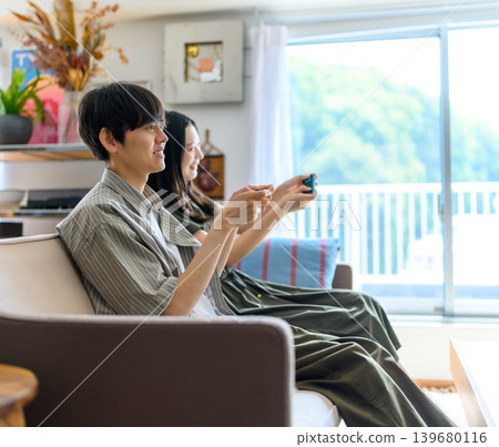 一男一女正在用遊戲手把玩遊戲。 139680116