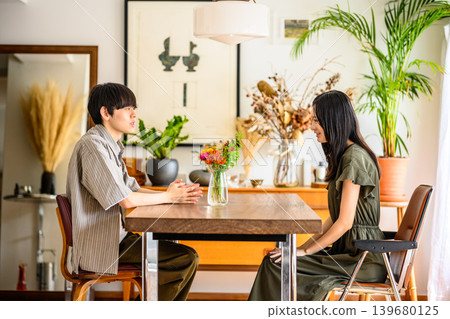 一男一女隔著桌子交談。 139680125
