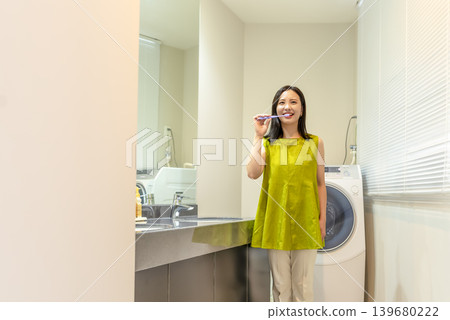 A young woman brushing her teeth in the changing room 139680222