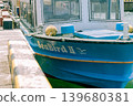 A small blue boat docked in the harbor 139680381