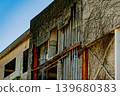 A decaying concrete building covered in ivy. 139680383