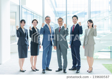 一群商務人士在辦公室裡擺出勝利的姿勢。 一群商務人士在辦公室裡擺出勝利的姿勢。 139680587