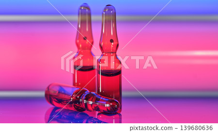Red glass medical ampoules close up on neon pink blue background Red glass medical ampoules close up on neon pink blue background 139680636