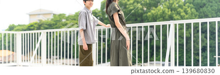一對年輕男女並肩站在陽台上。 139680830