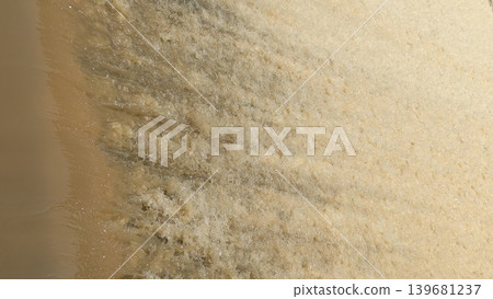 Abstract of fast-flowing, yellowish-brown water foaming and frothing as it rushes over an unseen edge creating a dynamic textured surface perfect for backgrounds and representing energy or pollution Abstract of fast-flowing, yellowish-brown water foaming and frothing as it rushes over an unseen edge creating a dynamic textured surface perfect for backgrounds and representing energy or pollution 139681237