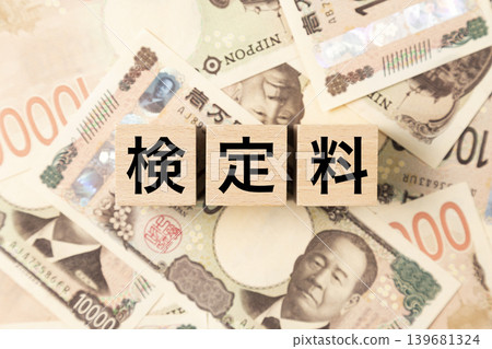 A block labeled "Examination Fee" and many 10,000 yen bills A block labeled "Examination Fee" and many 10,000 yen bills 139681324