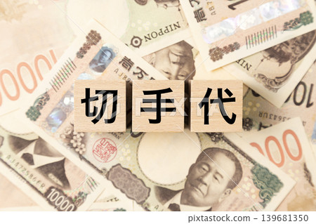 一塊標有「郵資」字樣的鈔票和許多面額為10000日元的鈔票。 一塊標有「郵資」字樣的鈔票和許多面額為10000日元的鈔票。 139681350