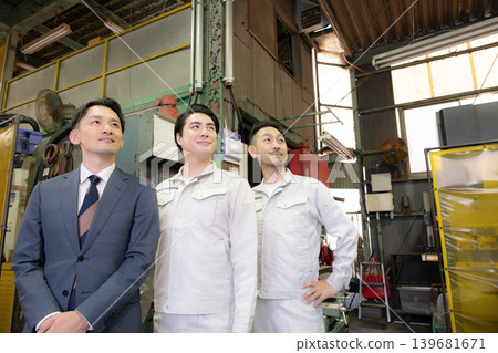 Portraits of teams working on the factory floor in manufacturing: Small and medium-sized enterprises and their people - images of looking up and gazing at the future and goals. Portraits of teams working on the factory floor in manufacturing: Small and medium-sized enterprises and their people - images of looking up and gazing at the future and goals. 139681671