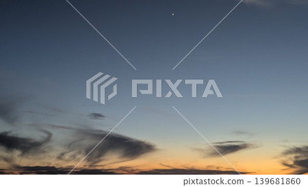 A serene sunrise sky with a deep blue-to-orange gradient and wispy clouds near the horizon. A single bright star or planet is visible in the upper center of the frame. A serene sunrise sky with a deep blue-to-orange gradient and wispy clouds near the horizon. A single bright star or planet is visible in the upper center of the frame. 139681860