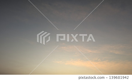 A subtle gradient sky transitions from slate blue to soft peach and gold, featuring delicate wispy clouds near the horizon at sunrise. Beautiful pastel hues of dawn. A subtle gradient sky transitions from slate blue to soft peach and gold, featuring delicate wispy clouds near the horizon at sunrise. Beautiful pastel hues of dawn. 139681942