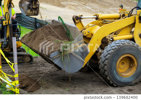 Construction workers use heavy equipment to dig move soil at site in rural area 139682400