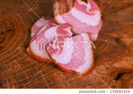 Sliced meat resting on wooden surface in kitchen setting Sliced meat resting on wooden surface in kitchen setting 139682429