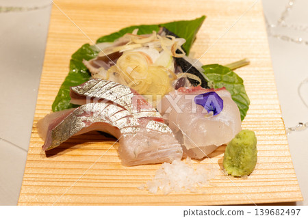 Delicious sashimi platter featuring cherry snapper, striped jack, and straw-grilled bonito. 139682497