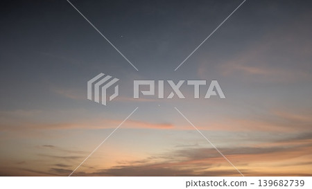 A soft sunrise sky with a gentle gradient of pink and orange at the bottom, blending into a darker blue at the top. Two small bright dots are visible, a star and possibly a planet. A soft sunrise sky with a gentle gradient of pink and orange at the bottom, blending into a darker blue at the top. Two small bright dots are visible, a star and possibly a planet. 139682739