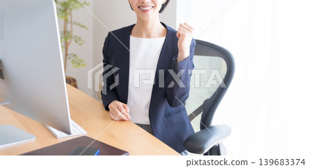 A businesswoman working on her desktop computer (making a victory pose) 139683374