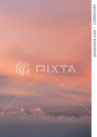 Pastel sunset clouds glowing with pink and peach tones in the evening sky. Calm outdoor atmosphere with soft layered cloud textures. Pastel sunset clouds glowing with pink and peach tones in the evening sky. Calm outdoor atmosphere with soft layered cloud textures. 139684189