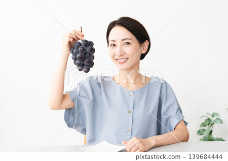 Woman eating Kyoho grapes Food image Woman eating Kyoho grapes Food image 139684444