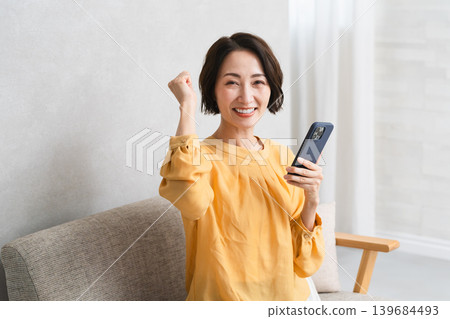 Woman operating a smartphone Lifestyle image Woman operating a smartphone Lifestyle image 139684493