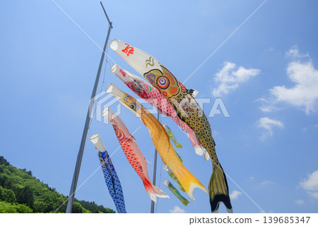 Carp streamers swimming in the early summer blue sky and over the foothills. Carp streamers swimming in the early summer blue sky and over the foothills. 139685347