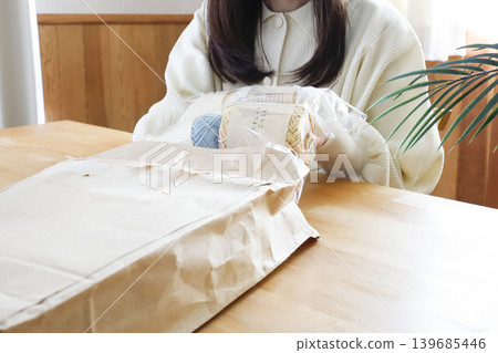 A woman looking at yarn in a brightly lit room 139685446