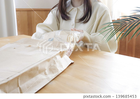 一位女士在燈光明亮的房間裡看著毛線。 一位女士在燈光明亮的房間裡看著毛線。 139685453