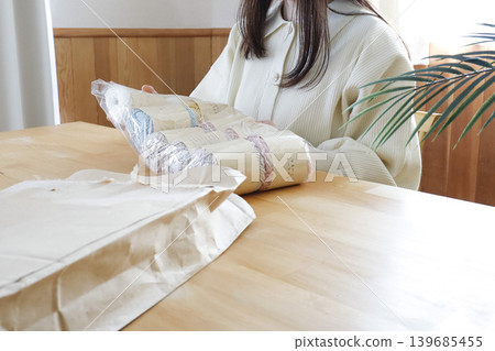 一位女士在燈光明亮的房間裡看著毛線。 一位女士在燈光明亮的房間裡看著毛線。 139685455