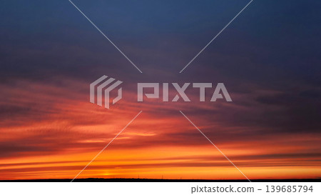 Dramatic colorful sunset sky with layered clouds above horizon 139685794