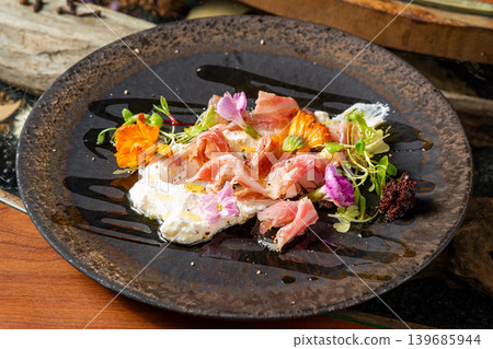 Prosciutto and cheese: A popular appetizer plate that pairs well with wine. Prosciutto and cheese: A popular appetizer plate that pairs well with wine. 139685944