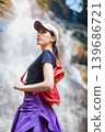 asian woman traveller relaxing in deep tropical jungle waterfall  139686721