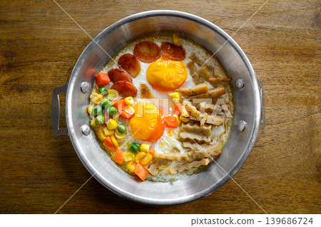 pan-fried egg with toppings on wooden table pan-fried egg with toppings on wooden table 139686724