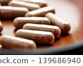 Macro shot of herbal supplement capsules placed on brown texture. Healthcare solution concept.  139686940