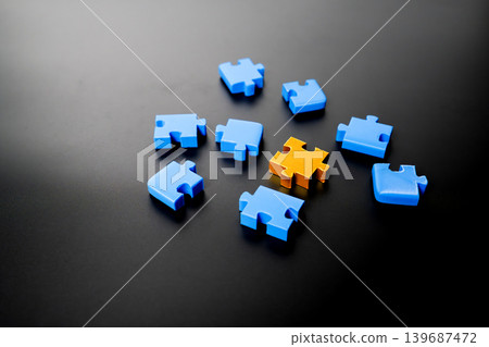Scattered blue puzzle pieces on a dark surface with one unique Gold piece highlighting leadership and individuality. Professional concept for business strategy, uniqueness, and problem solving. Scattered blue puzzle pieces on a dark surface with one unique Gold piece highlighting leadership and individuality. Professional concept for business strategy, uniqueness, and problem solving. 139687472