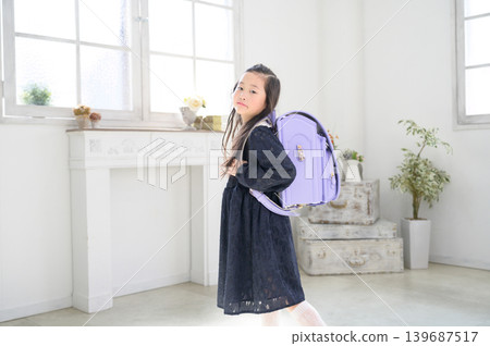 一個日本女孩背著書包轉過身來。 一個日本女孩背著書包轉過身來。 139687517