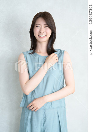 一位日本女性在燈光明亮的房間裡微笑。 一位日本女性在燈光明亮的房間裡微笑。 139687591