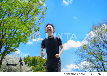 身穿運動服的日本男子手持塑膠瓶 身穿運動服的日本男子手持塑膠瓶 139687615