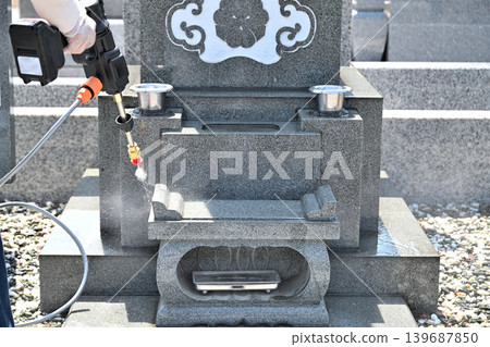 Seniors cleaning graves with a high-pressure washer Seniors cleaning graves with a high-pressure washer 139687850