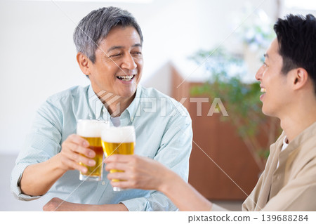 家庭:父子倆在喝啤酒 家庭:父子倆在喝啤酒 139688284