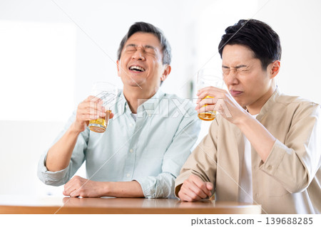 家庭:父子倆在喝啤酒 家庭:父子倆在喝啤酒 139688285