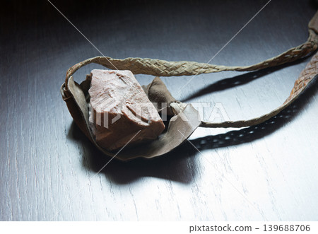 Sling with stone on wooden background Sling with stone on wooden background 139688706
