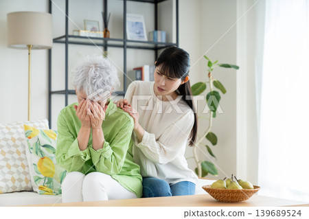A grieving senior mother and her middle-aged daughter A grieving senior mother and her middle-aged daughter 139689524