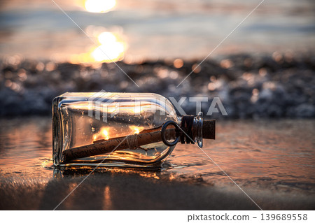 Message in glass bottle on sandy beach at sunset. 139689558