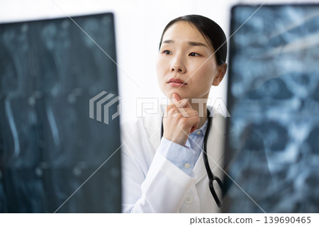 一位身穿白大褂的日本女醫生正在檢查X光片。 139690465