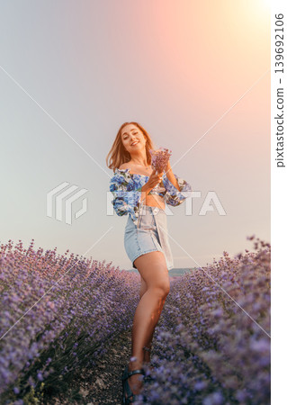 Woman lavender field sunset holding flowers in blooming meadow during golden hour for summer travel and relaxation Woman lavender field sunset holding flowers in blooming meadow during golden hour for summer travel and relaxation 139692106