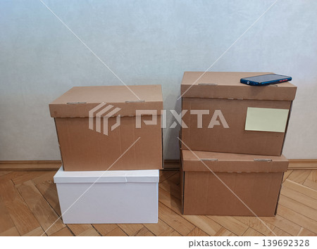 Stack of Moving Cardboard Boxes with Smartphone Stack of Moving Cardboard Boxes with Smartphone 139692328
