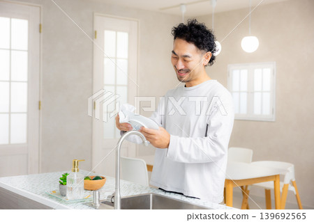A man standing in the kitchen 139692565