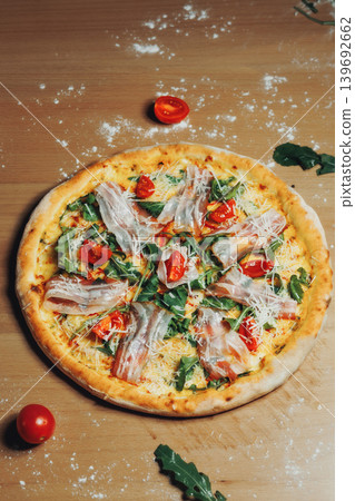 Fresh pizza rests on wooden table, lightly dusted with flour Fresh pizza rests on wooden table, lightly dusted with flour 139692662
