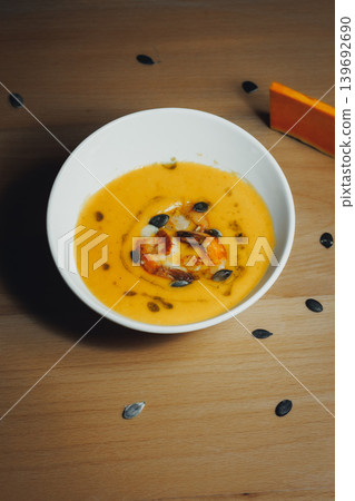 Pumpkin soup with roasted seeds, warm and inviting on wood Pumpkin soup with roasted seeds, warm and inviting on wood 139692690