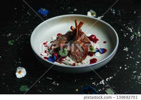 Luxurious plated lamb dish, artfully arranged with flowers and sauce Luxurious plated lamb dish, artfully arranged with flowers and sauce 139692701